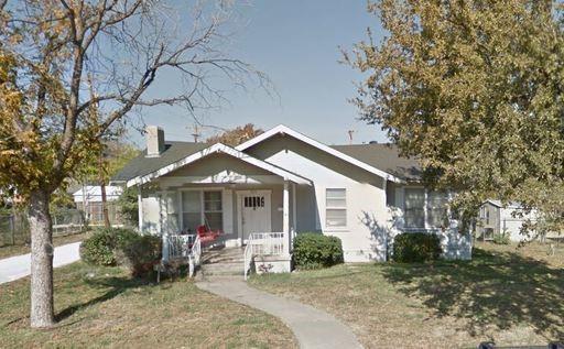 a front view of a house with a yard and trees