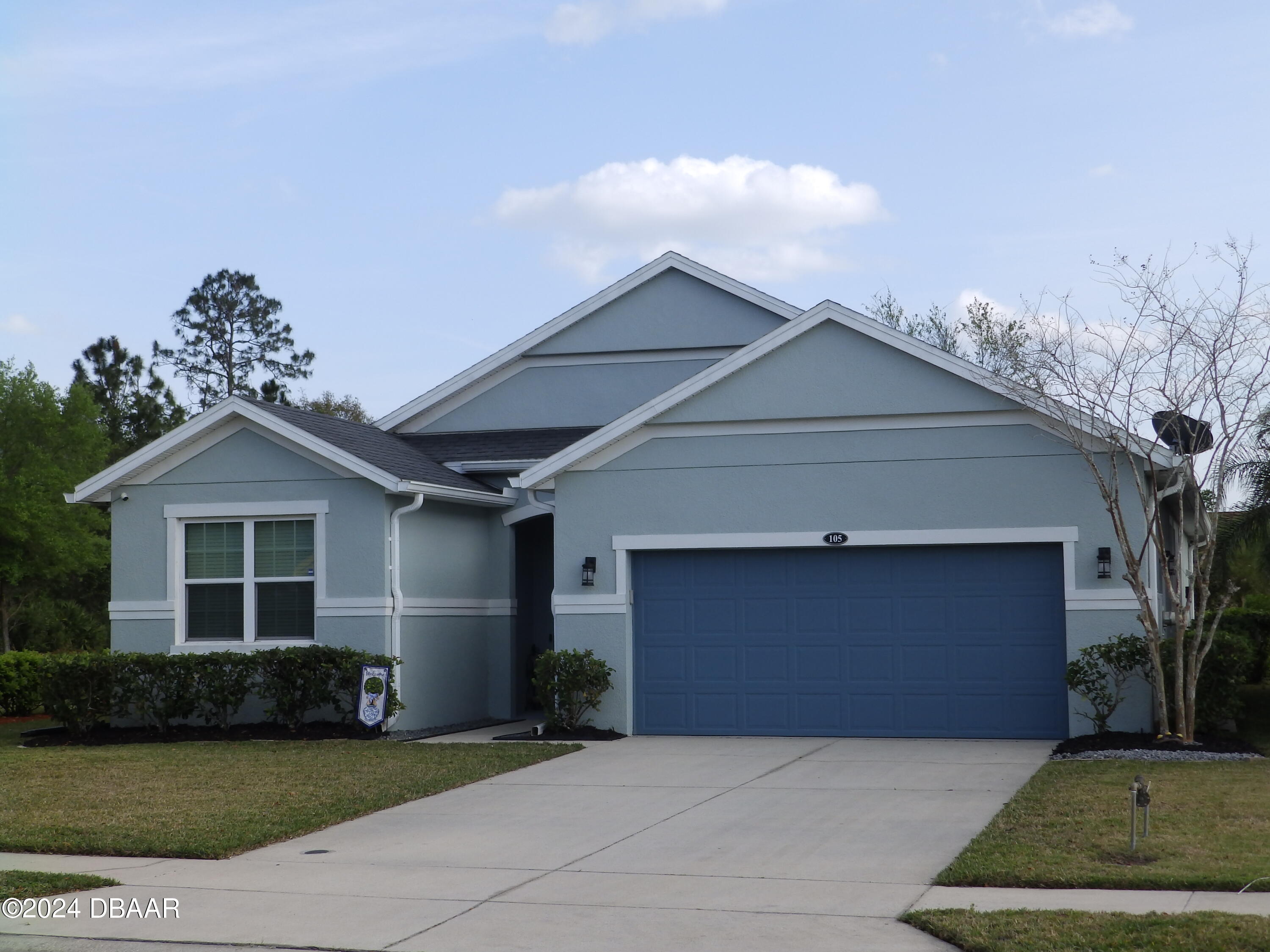 a front view of a house with a garden and garage