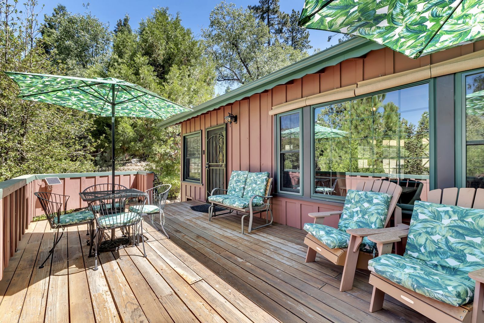 a patio with wooden floor table and chairs