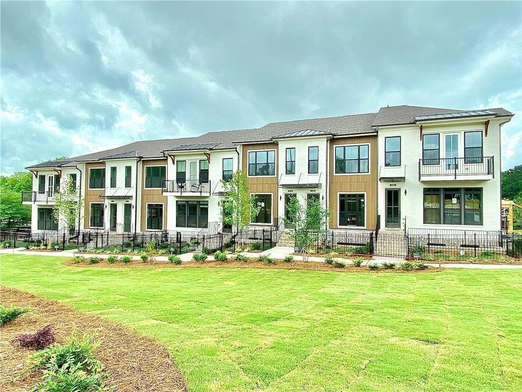 a front view of building with yard and outdoor seating