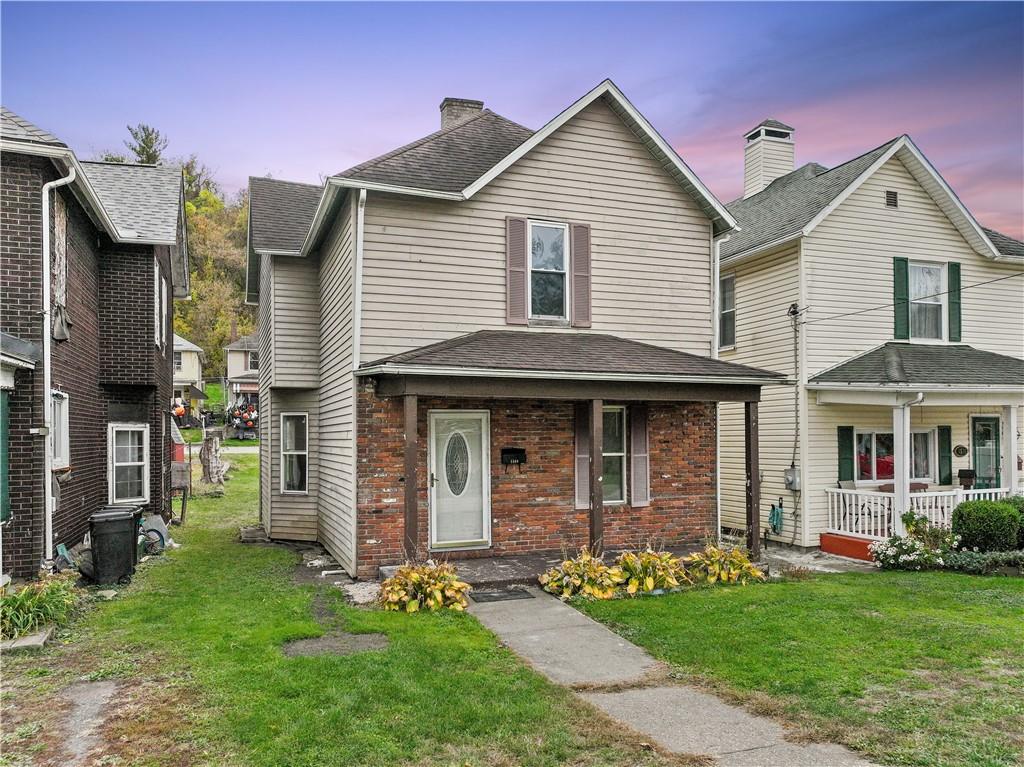 a front view of a house with a garden and yard