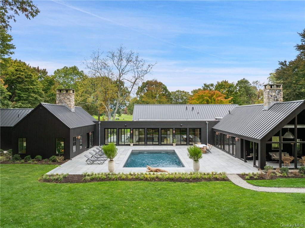 a view of a house with a big yard potted plants and large tree