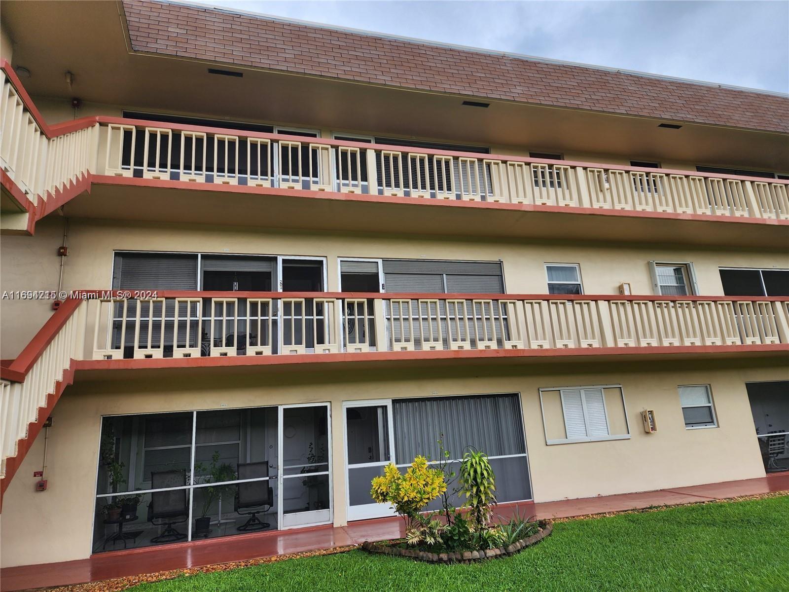 a view of a house with a deck and a yard