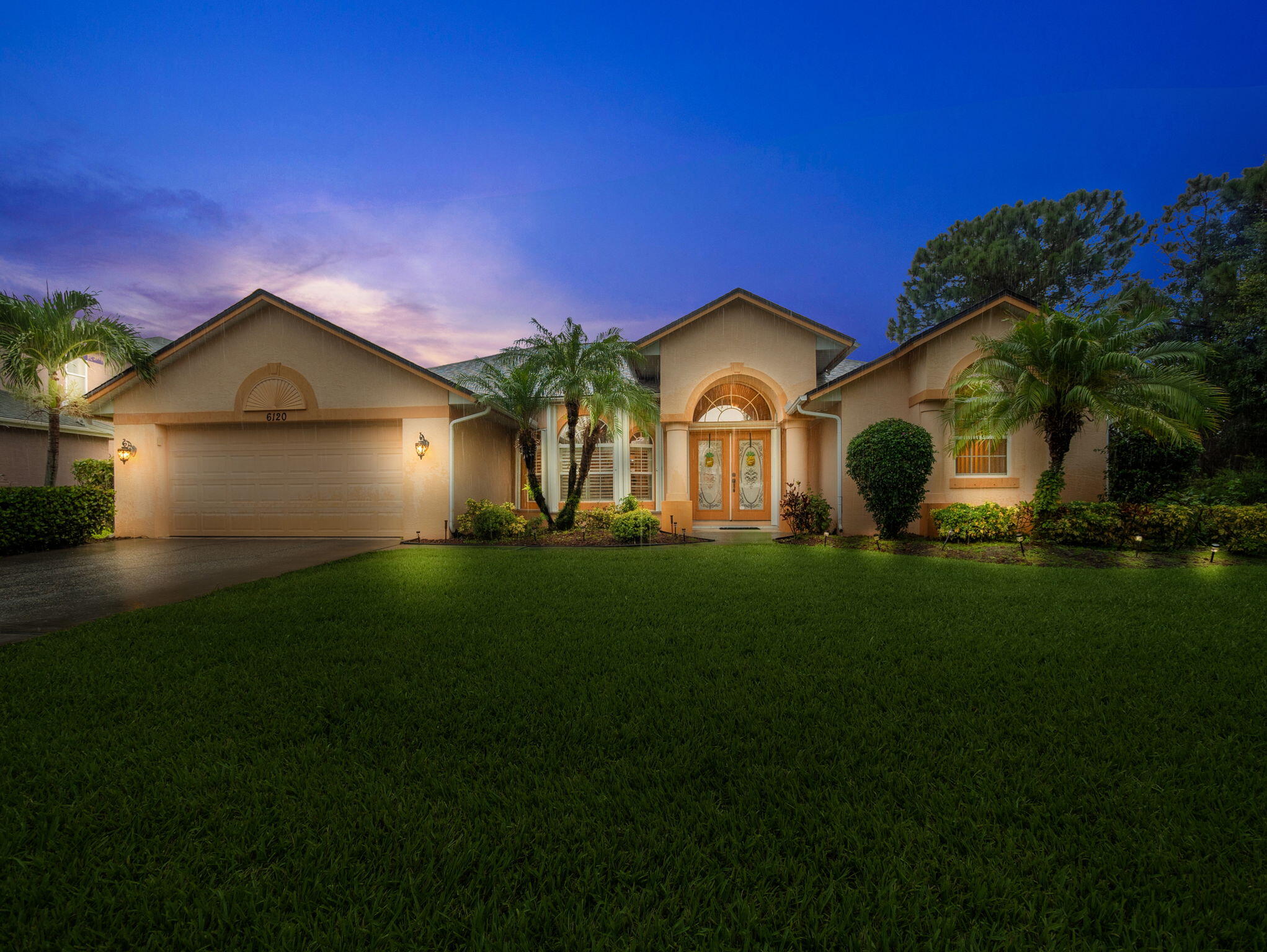 a front view of a house with a garden and yard