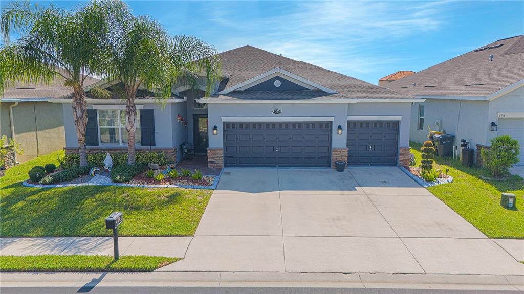 a view of a house with small yard plants and palm trees