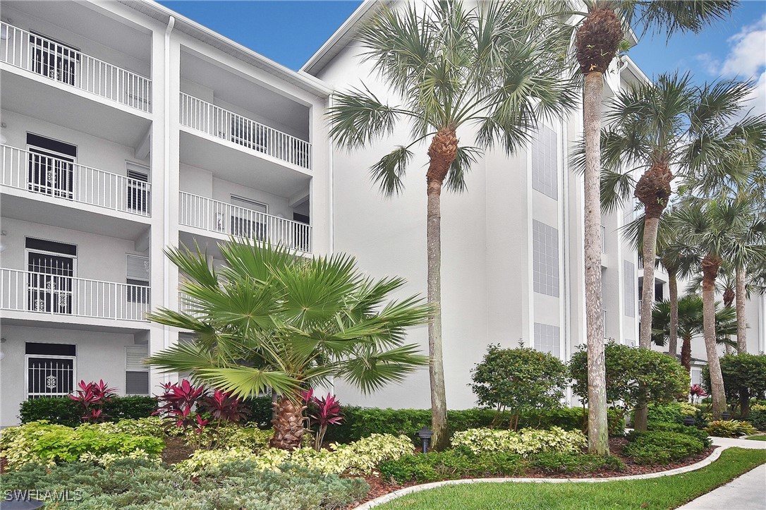 a front view of multi story residential apartment building with yard and green space