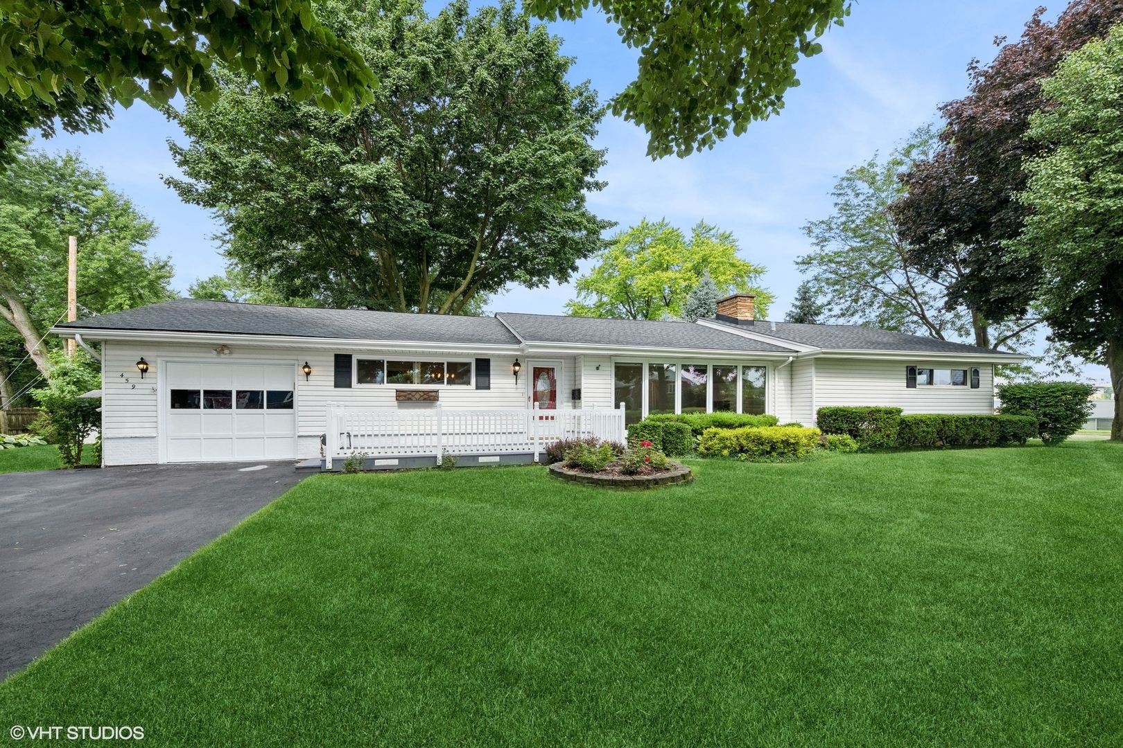 a front view of a house with a yard and trees