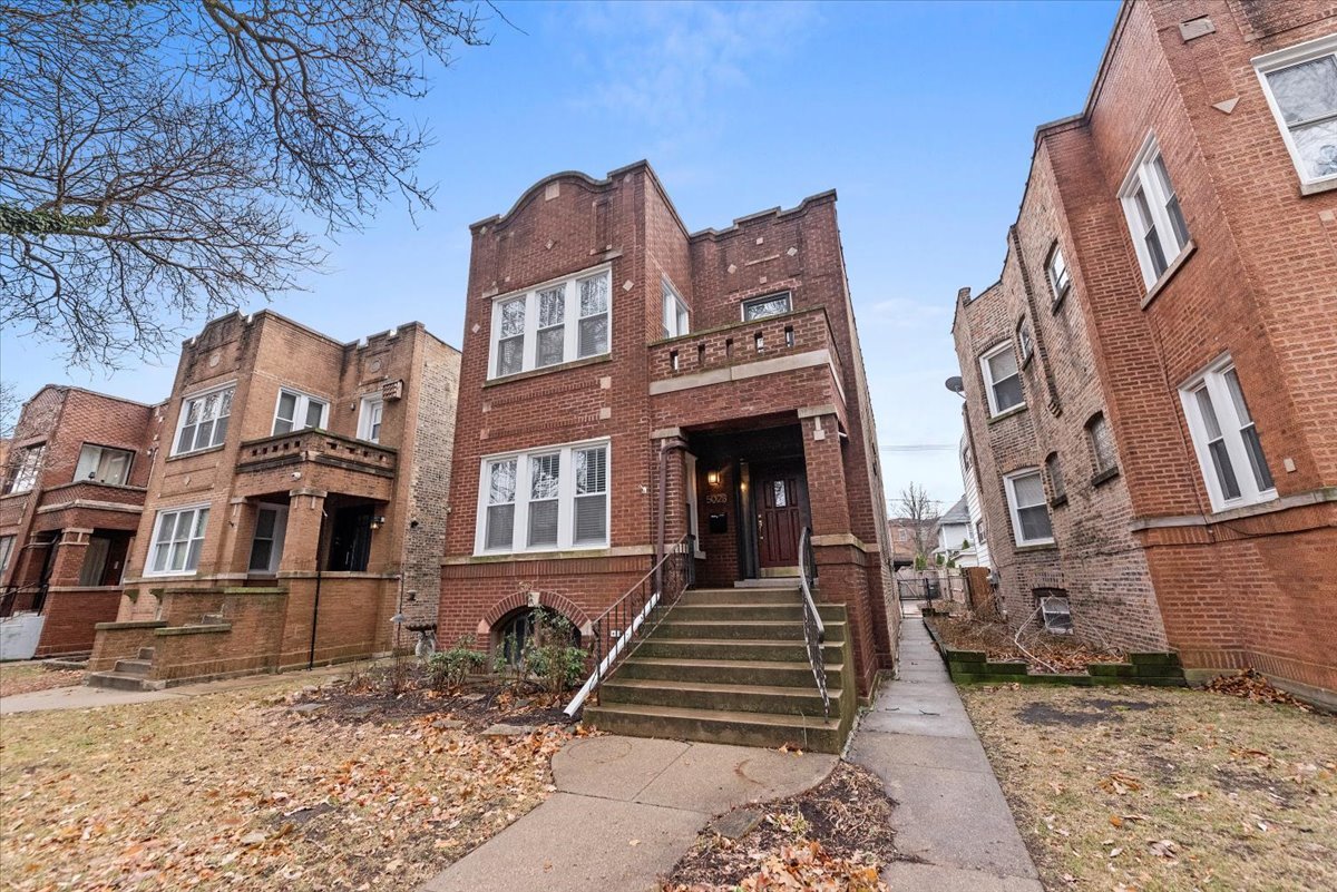 a front view of a residential apartment building with a yard