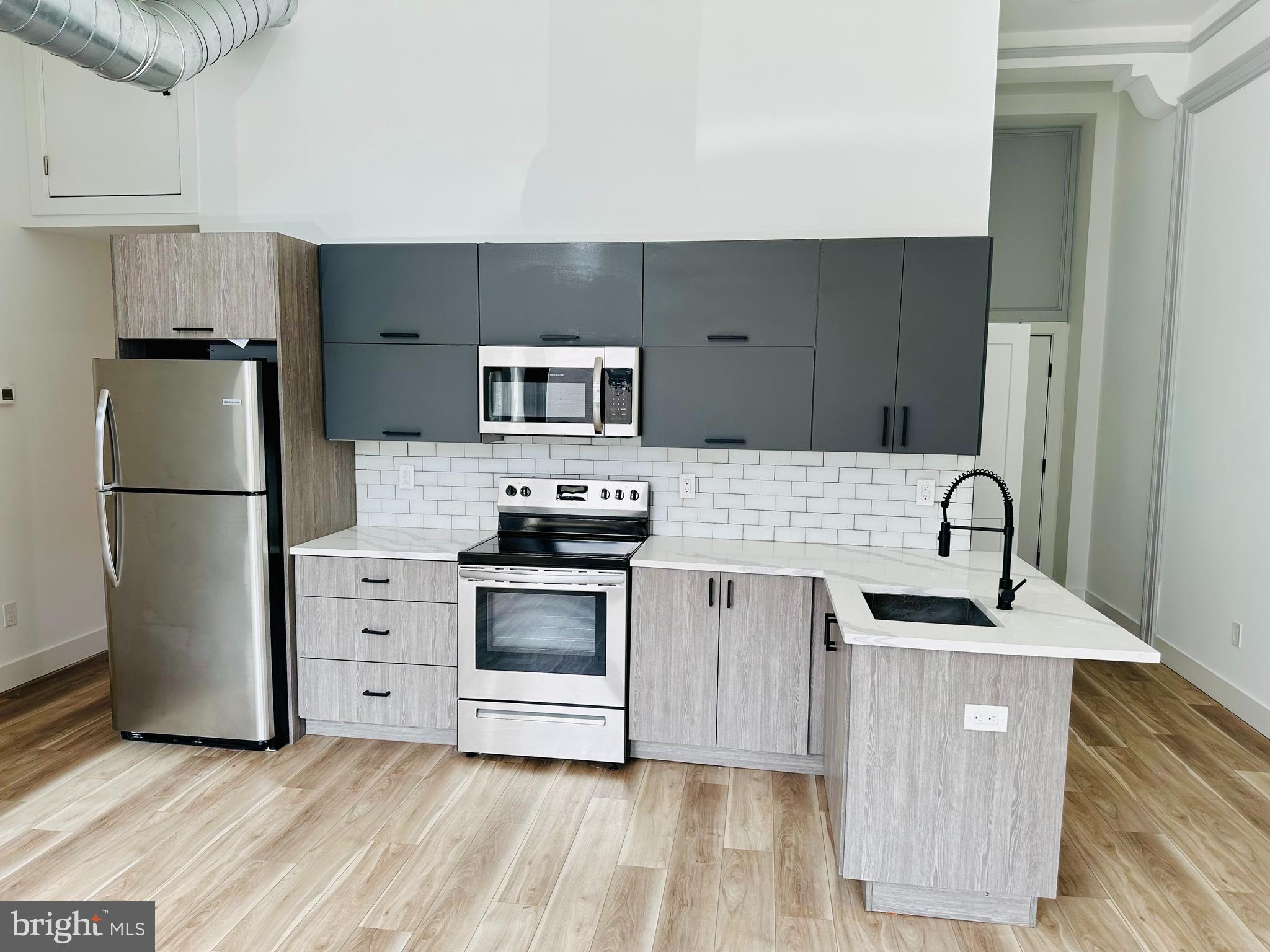 a kitchen with stainless steel appliances a refrigerator sink and stove