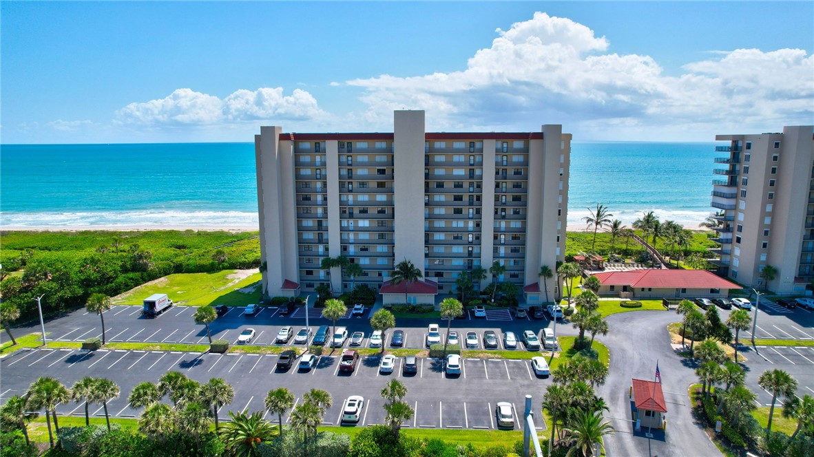 a view of a multi story residential apartment building with a yard