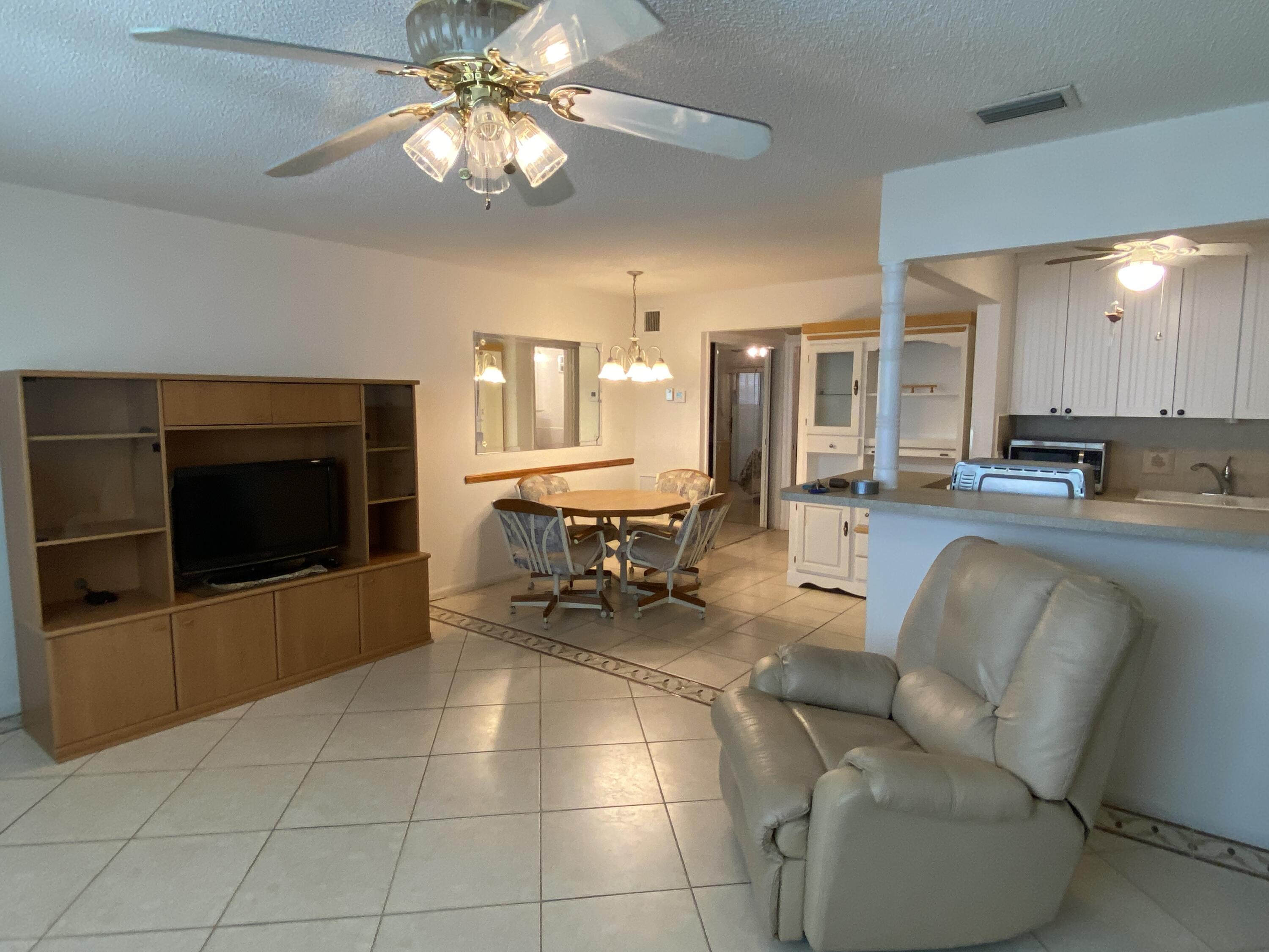 a living room with couches a dining table and kitchen view