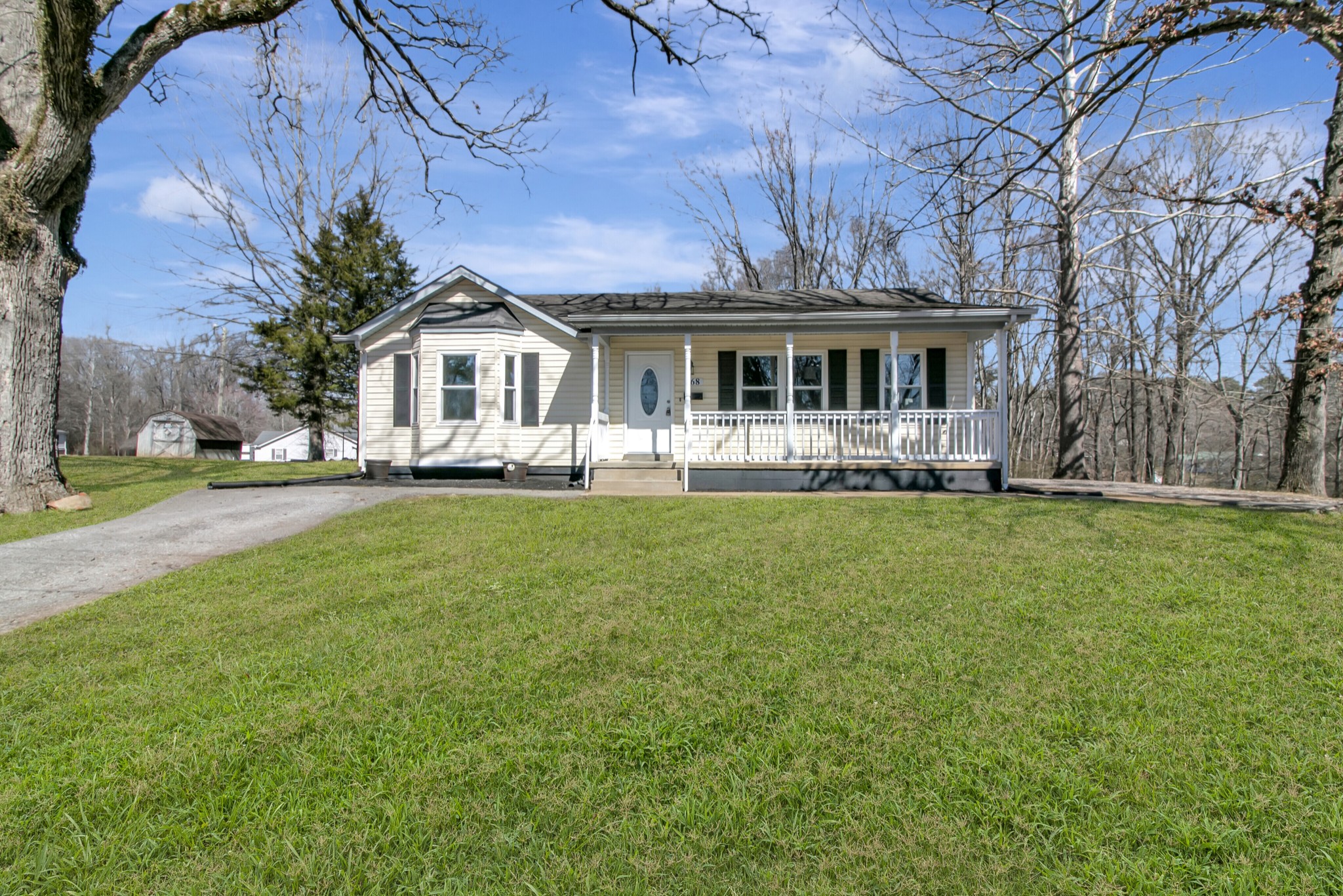 a front view of a house with a garden and trees