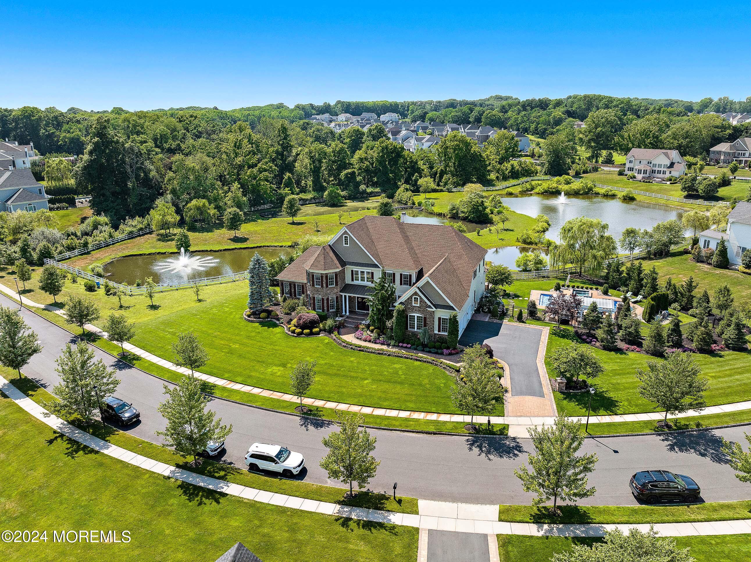 an aerial view of a house with a garden and lake view