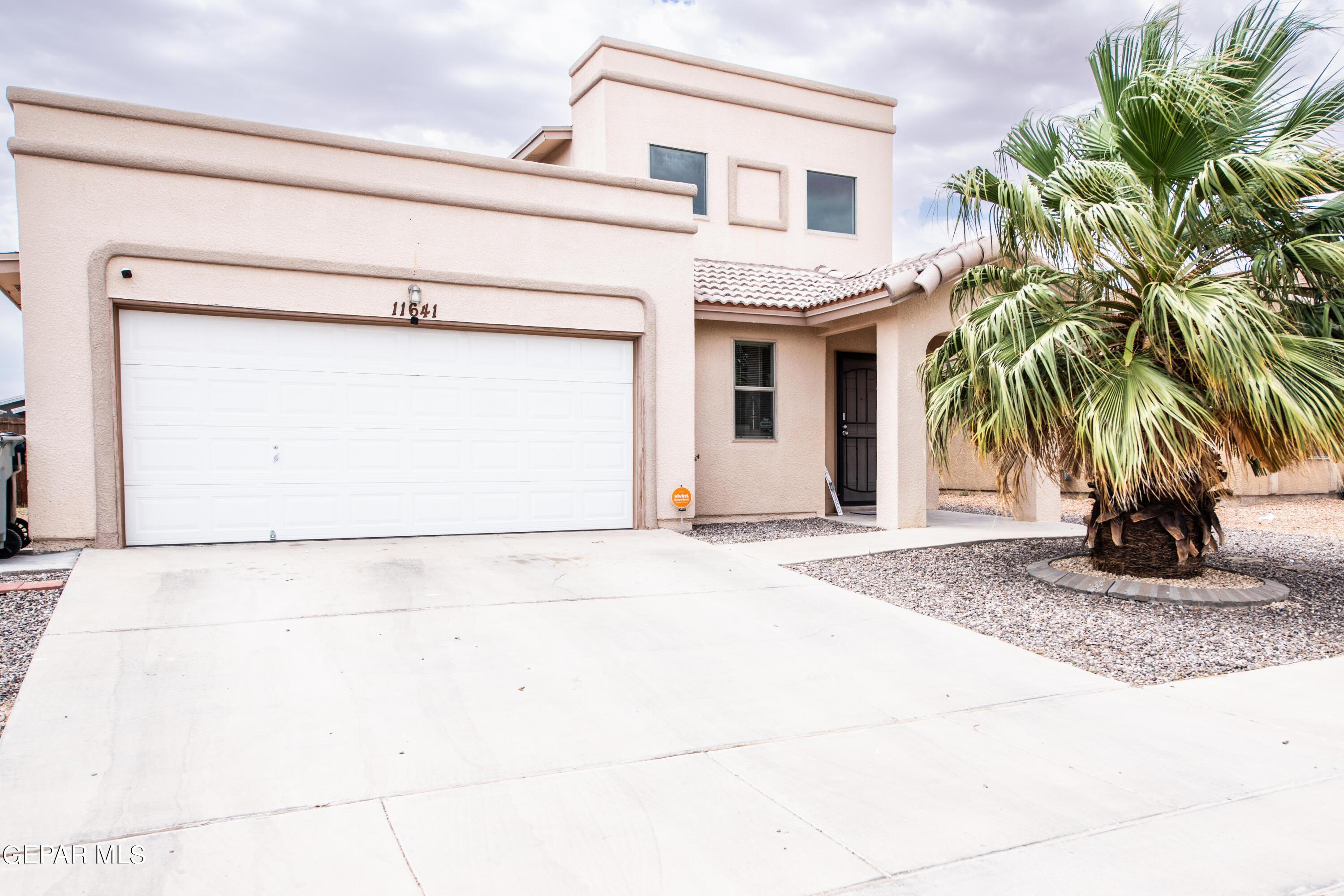 a front view of a house with a yard and a garage