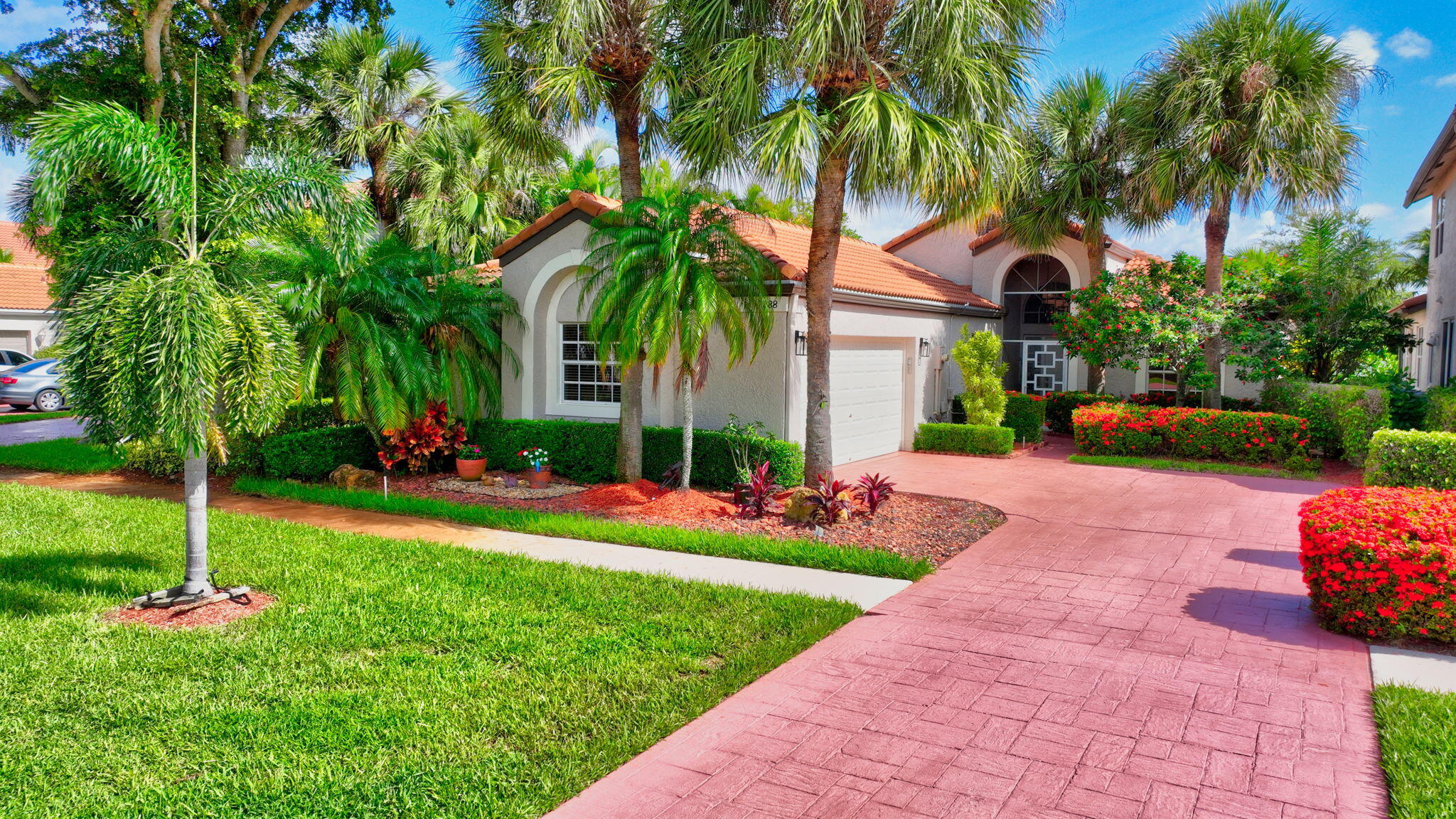 a front view of a house with fountain and potted plants