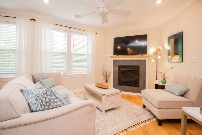 a living room with furniture a flat screen tv and a fireplace