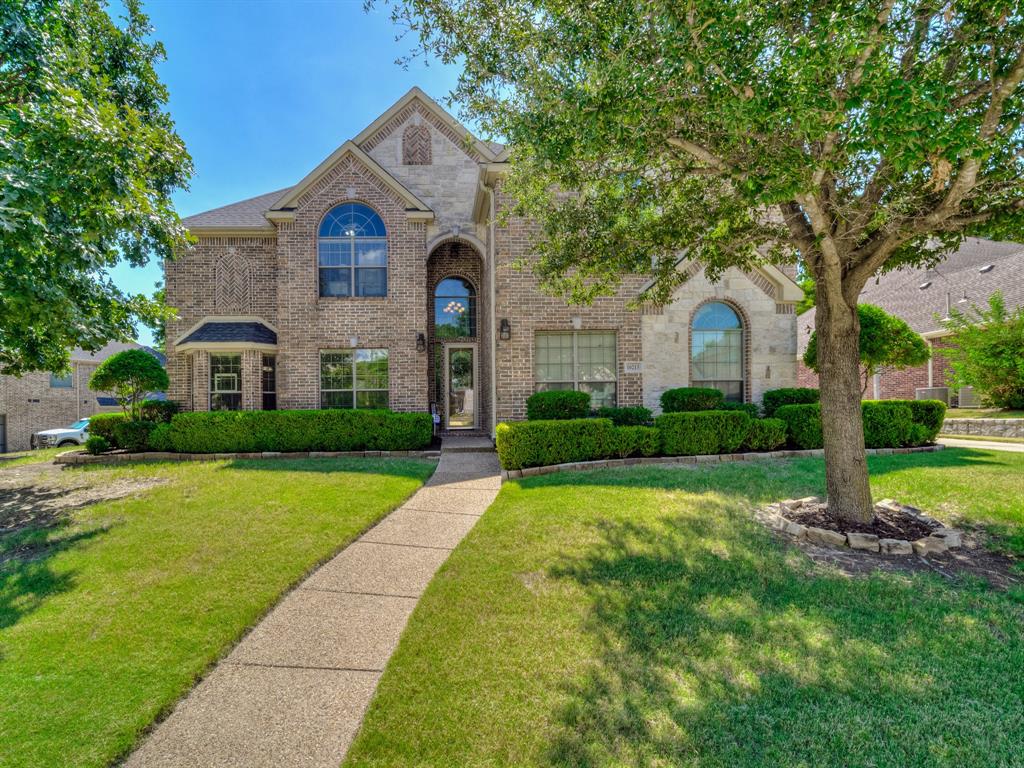 a front view of a house with yard and green space