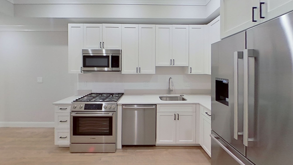 a kitchen with stainless steel appliances a stove a sink and a refrigerator