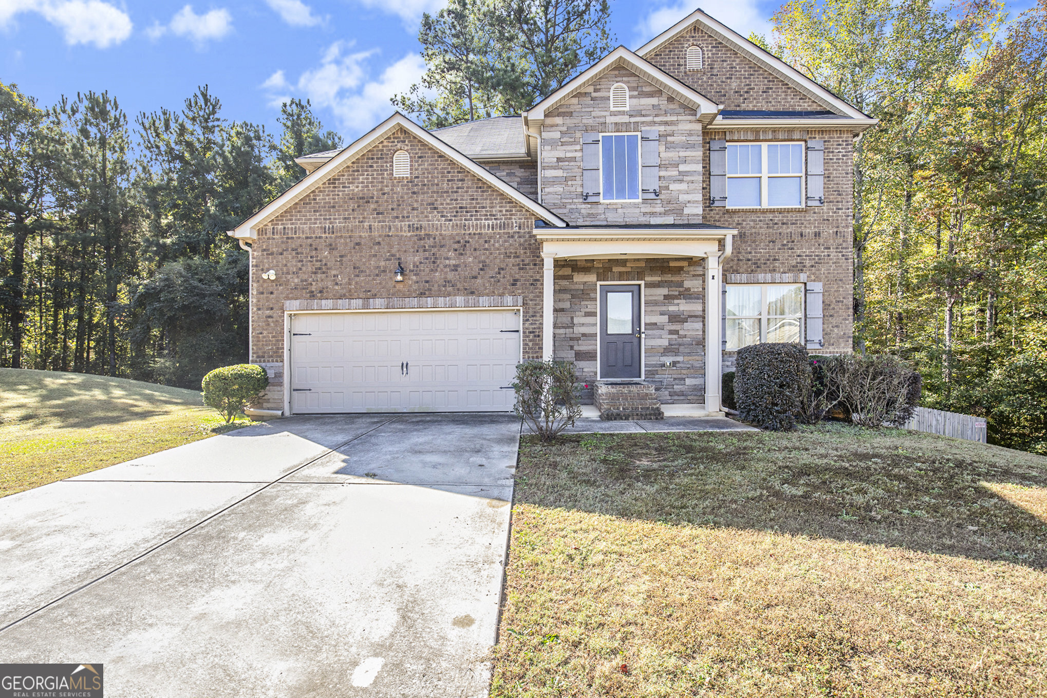 a front view of a house with a yard and garage