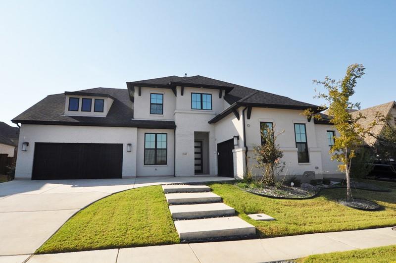 a front view of a house with a yard garage and outdoor seating