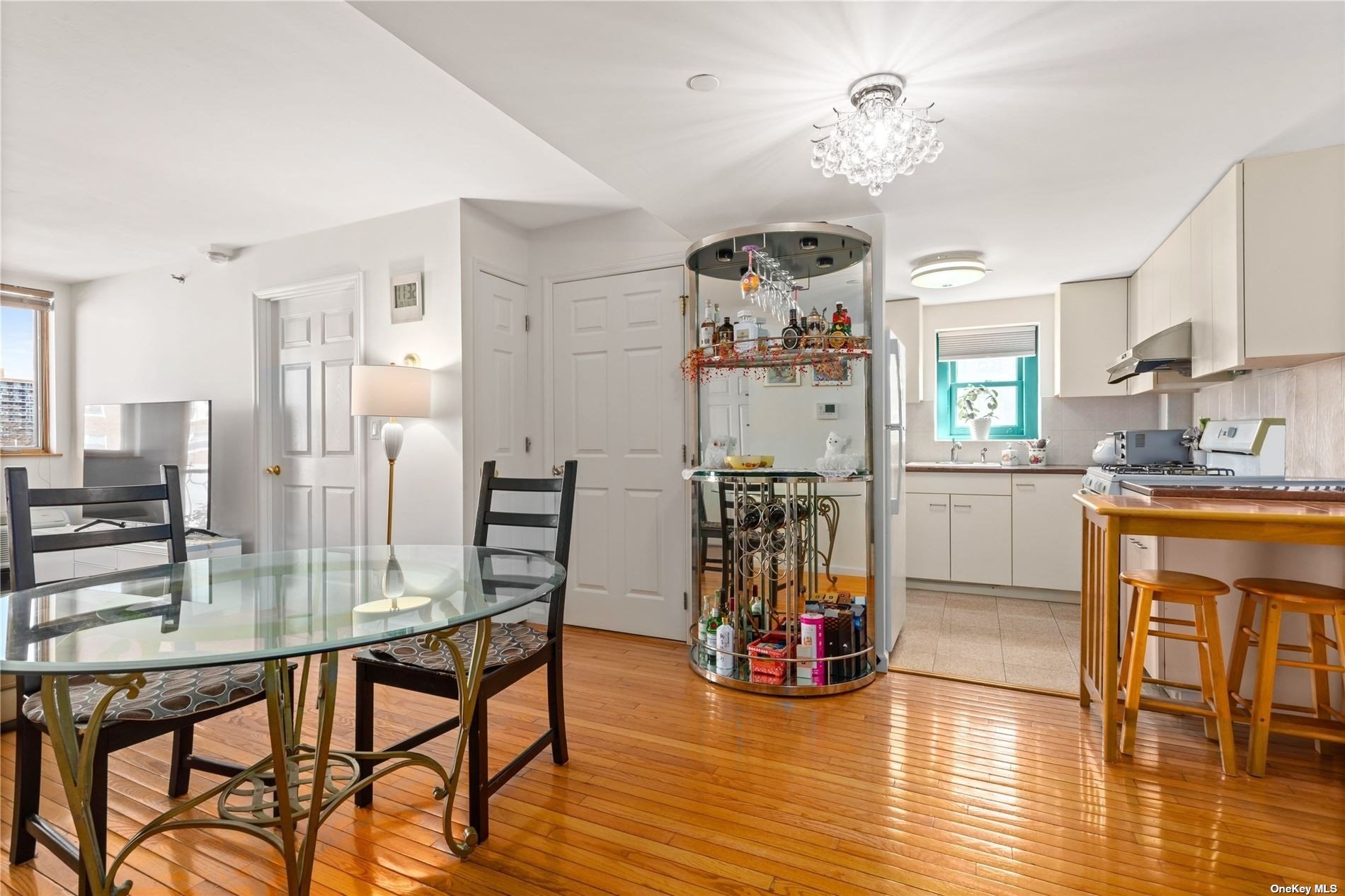 a kitchen with stainless steel appliances granite countertop a dining table chairs refrigerator and cabinets