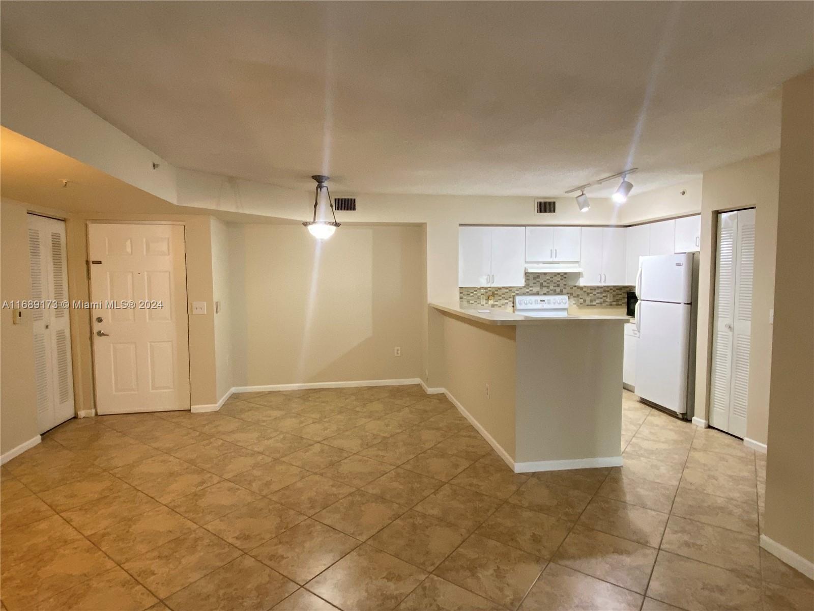 a view of a kitchen with kitchen island wooden floor center island stainless steel appliances and cabinets