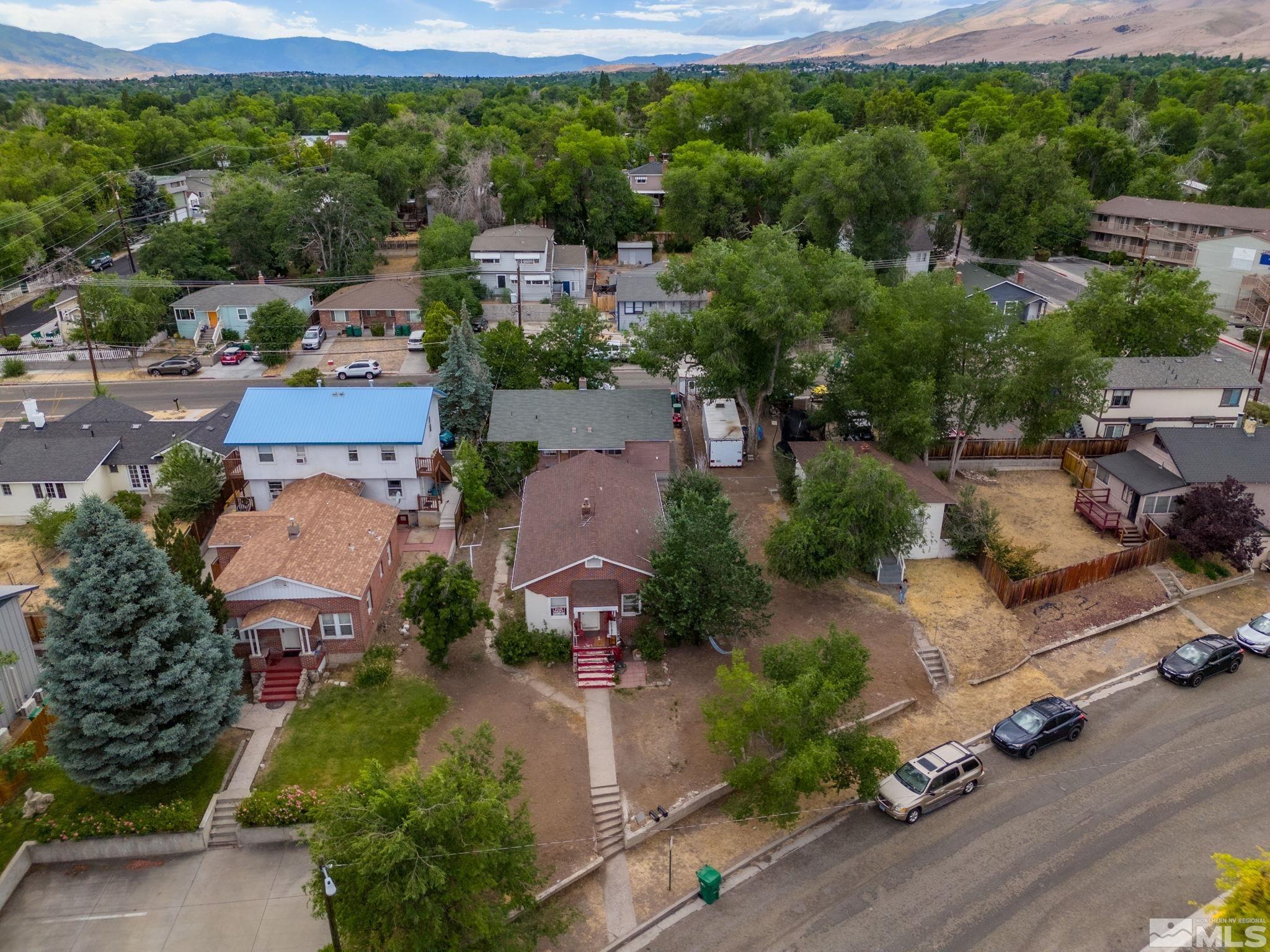 an aerial view of a city with lots of residential buildings ocean and mountain view in back