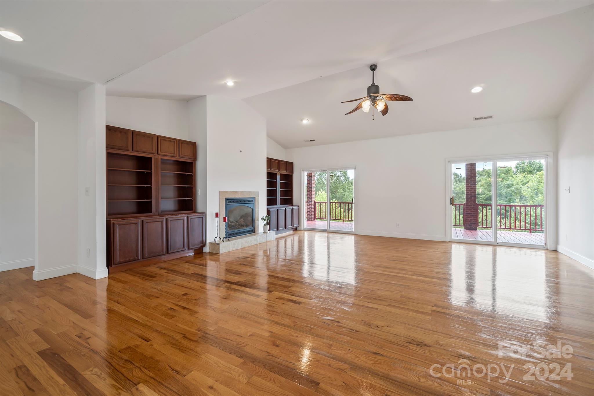 a view of empty room with wooden floor and windows