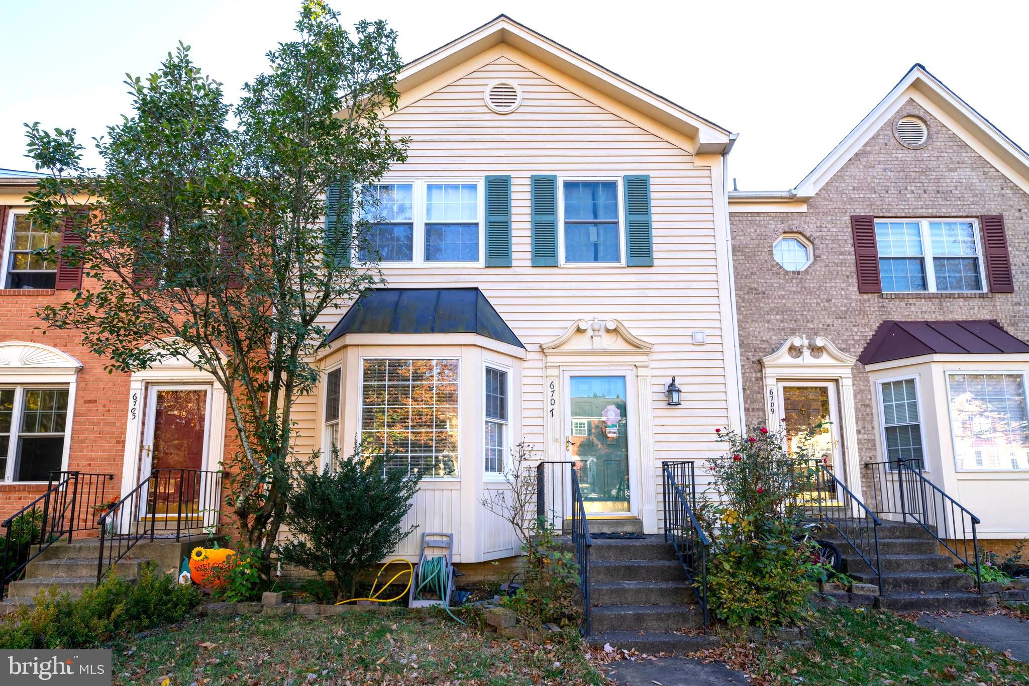 a front view of a house with a yard and trees