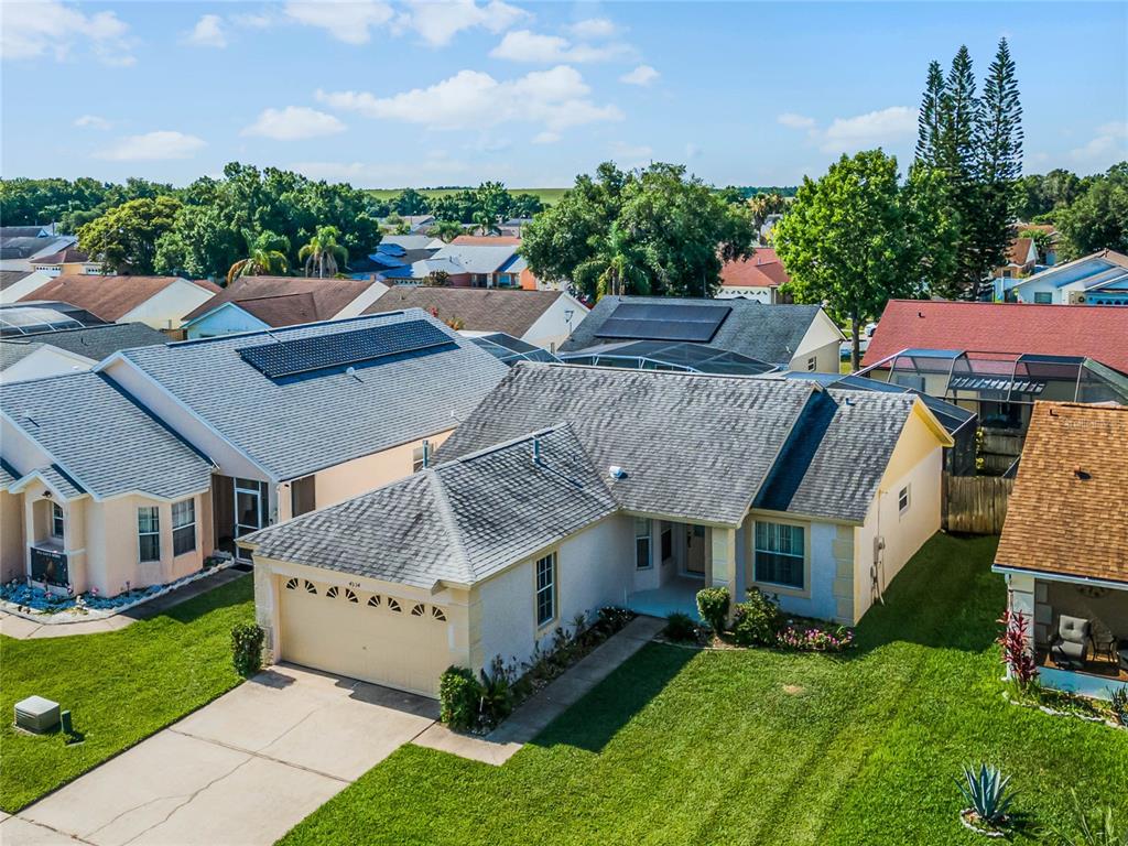 a aerial view of a house with a big yard and potted plants