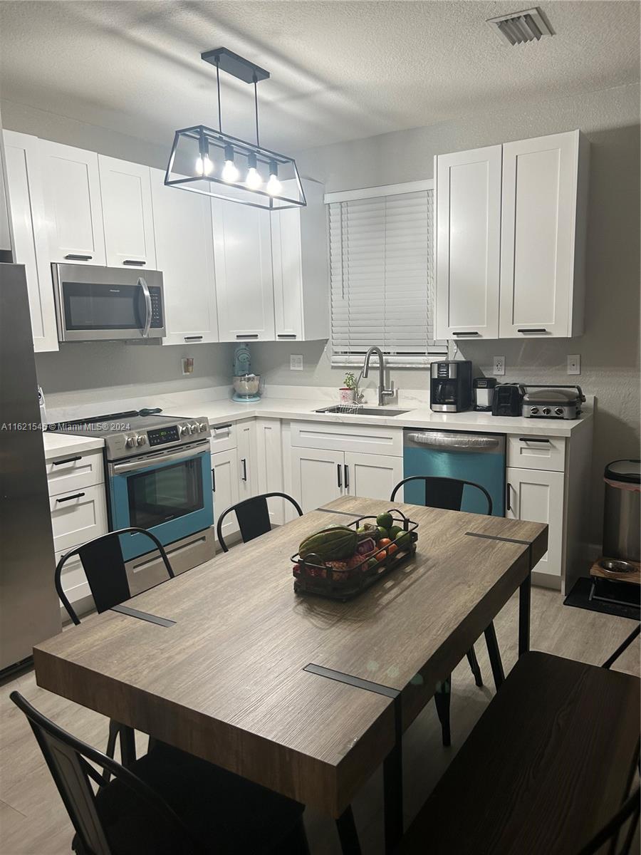 a kitchen with a table chairs stove and cabinets