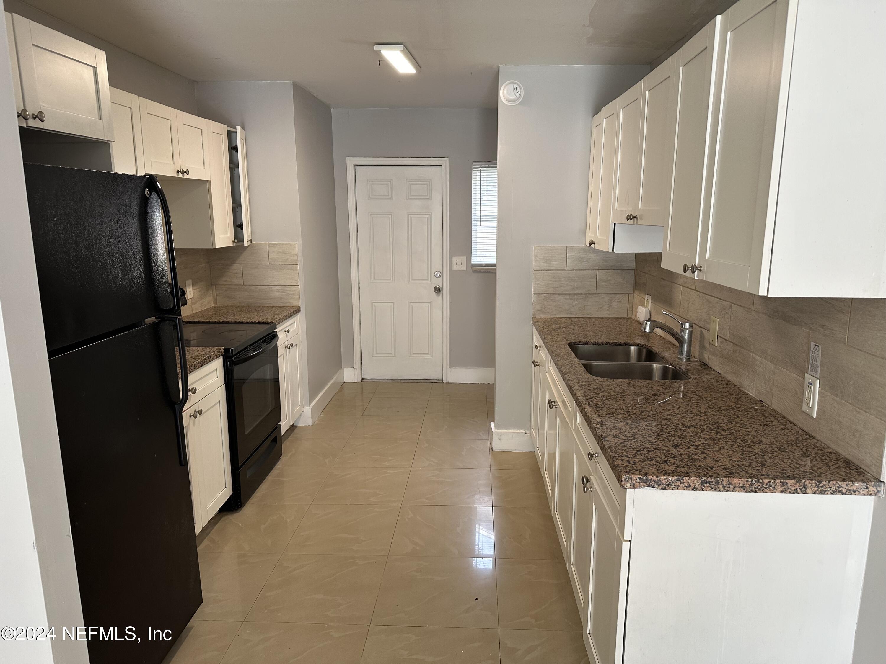 a kitchen with stainless steel appliances granite countertop a refrigerator a stove and a sink