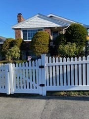 a view of a small house with wooden fence