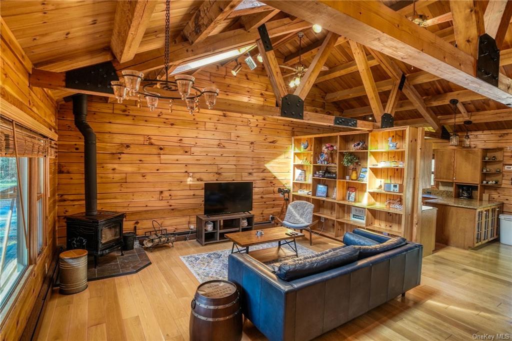 a living room with stainless steel appliances kitchen island granite countertop a stove and a wooden floors