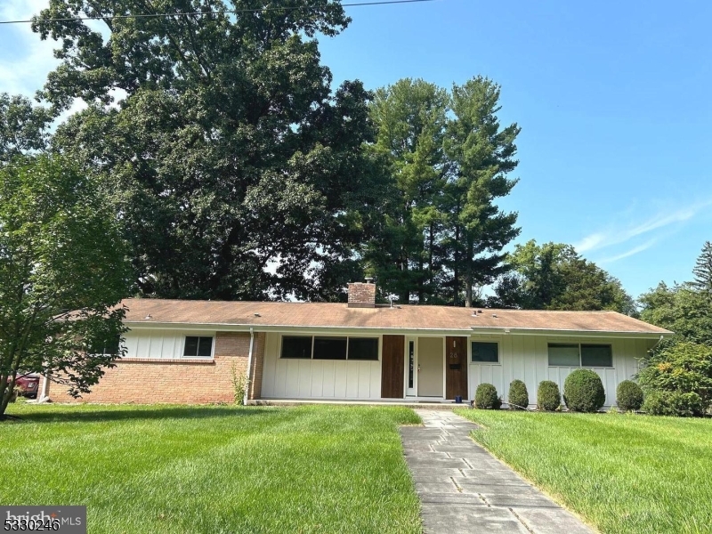 a front view of a house with a yard and trees