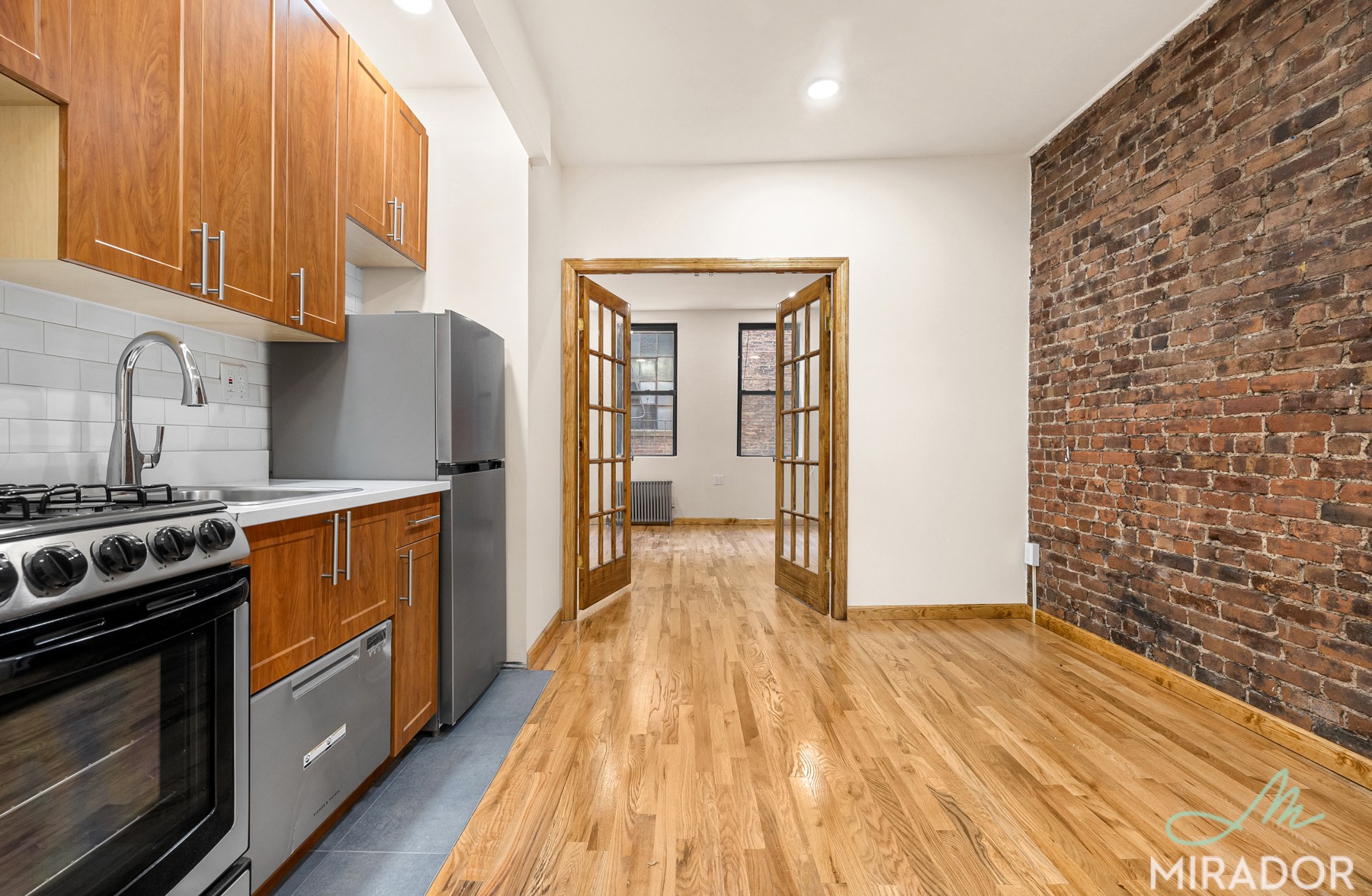 a kitchen with granite countertop wooden floors and stainless steel appliances