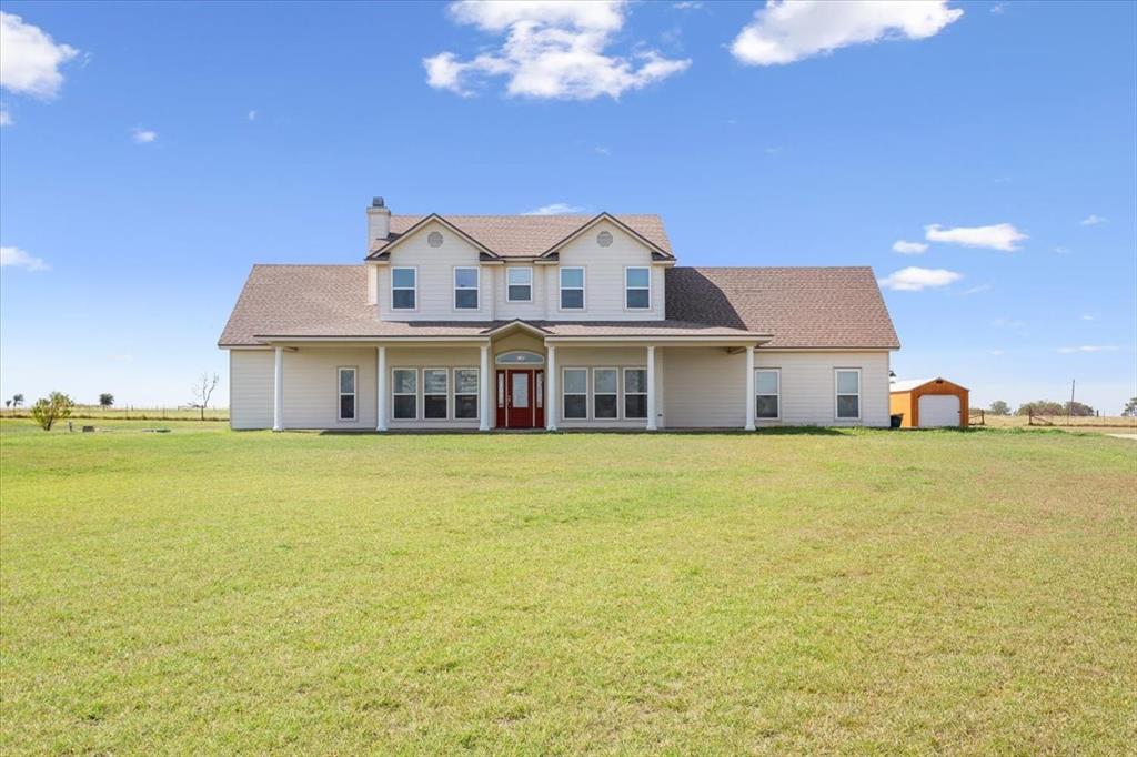 a front view of a house with a big yard