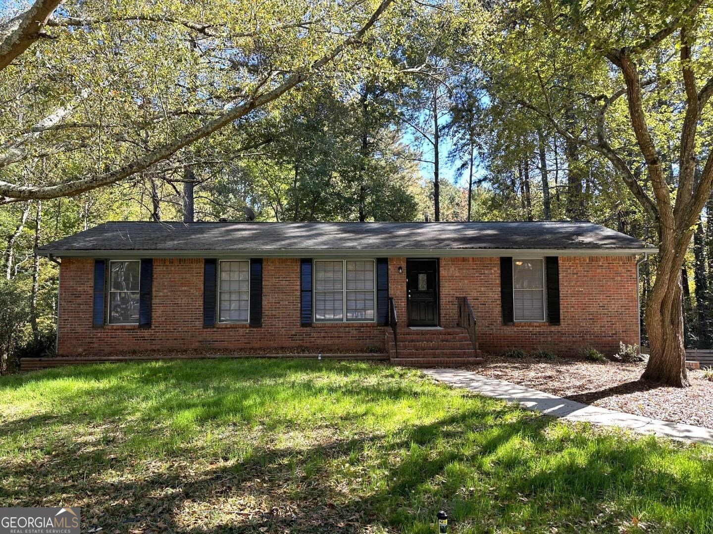 a view of house with a yard and large tree