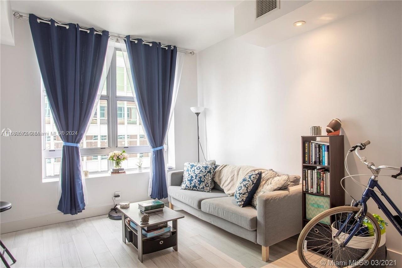 a living room with furniture a window and a wooden floor