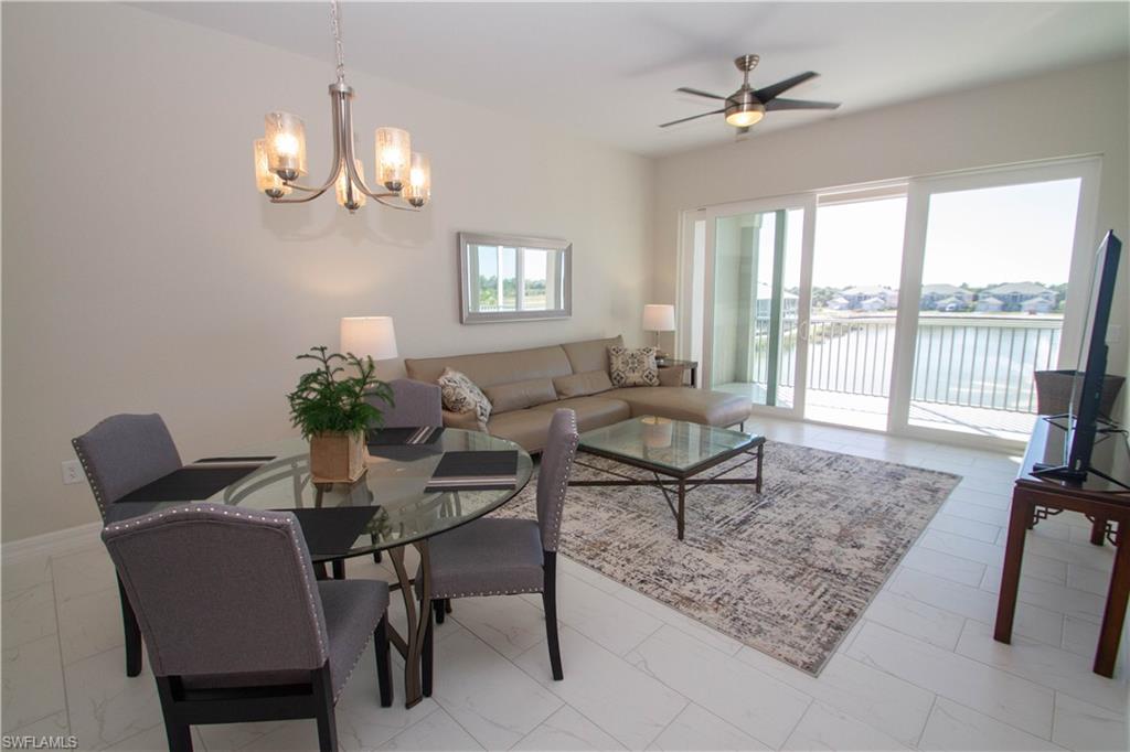 a dining room with furniture a rug a potted plant and a chandelier