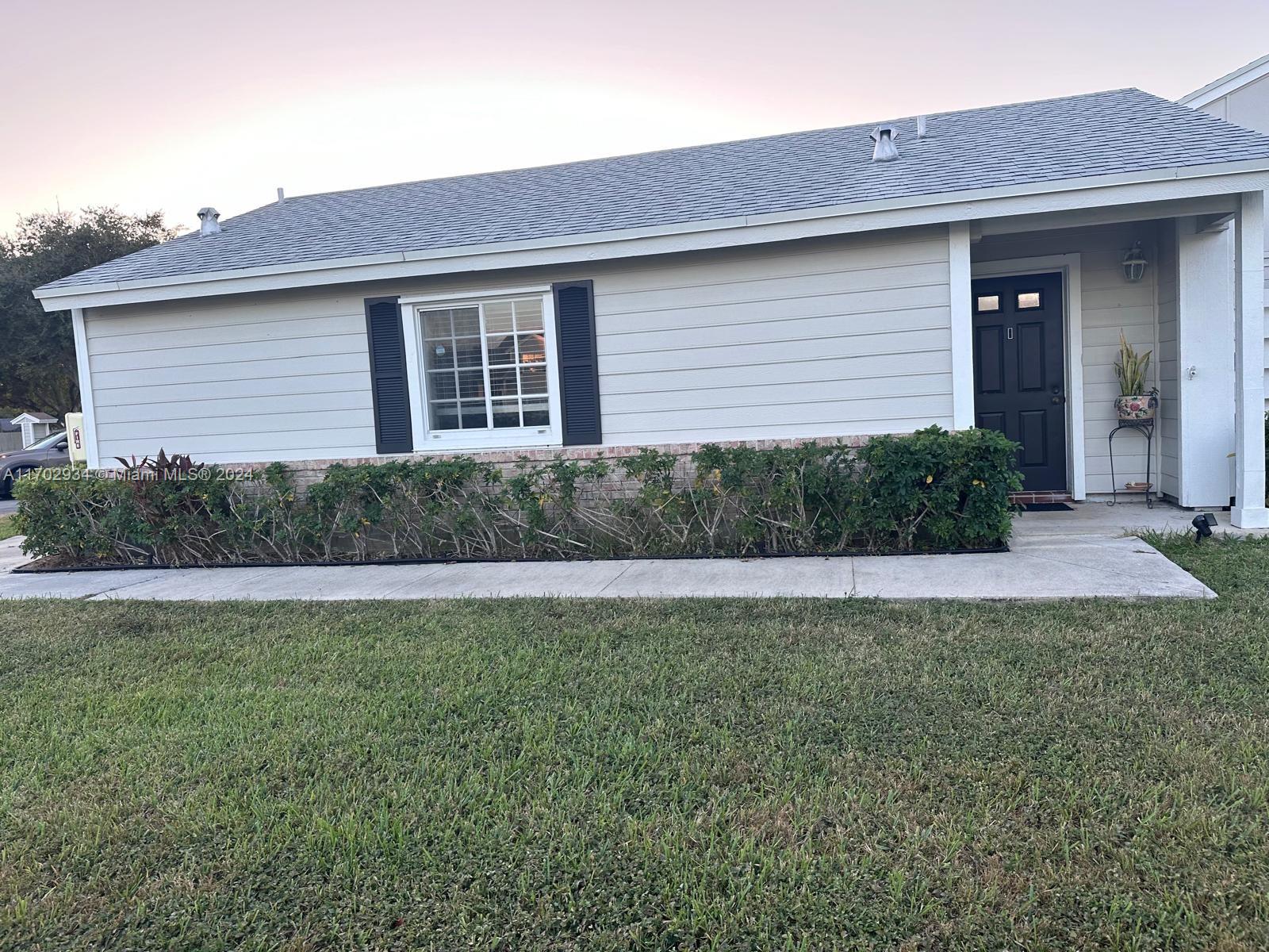 a front view of a house with yard and outdoor seating