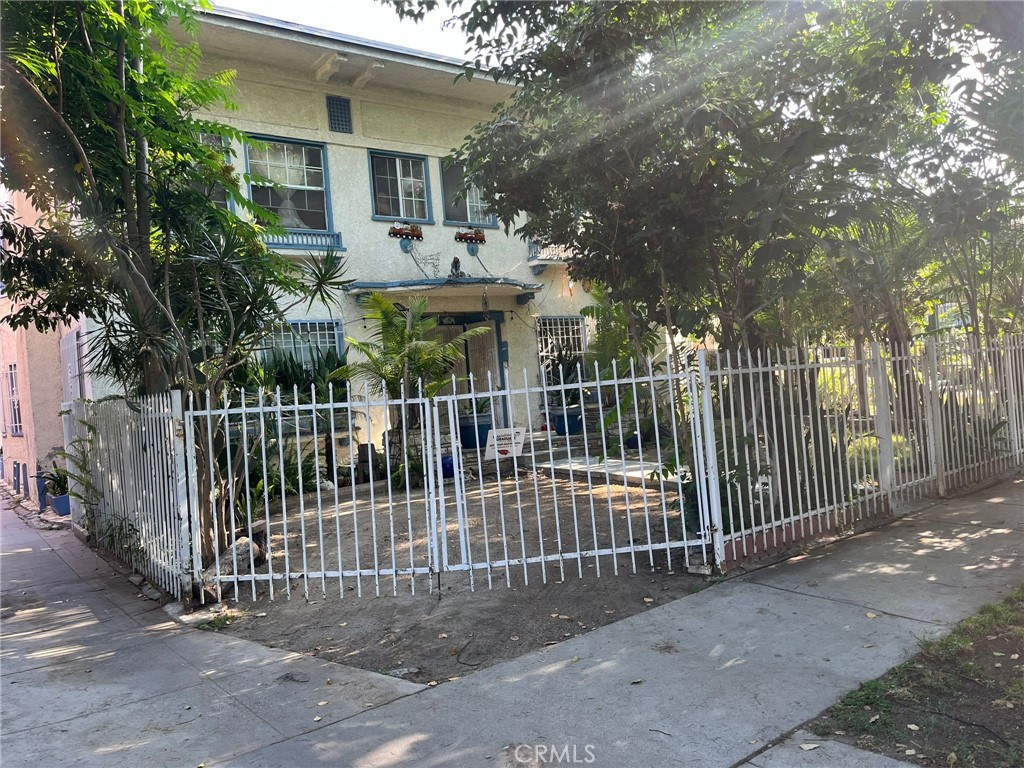 a view of a house with a fence and a trees