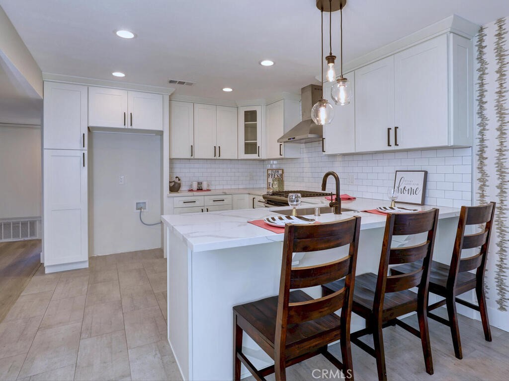 a kitchen with kitchen island a stove a table and chairs in it