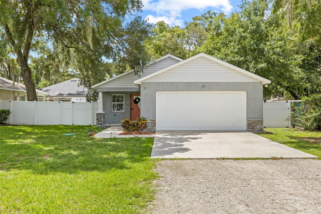 a view of a house with a yard and a garage