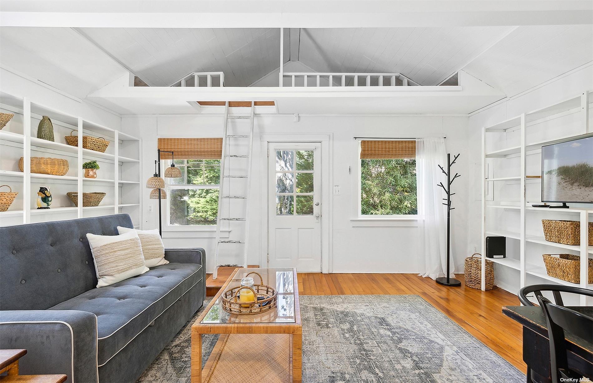 a living room with furniture hardwood floor and a large window