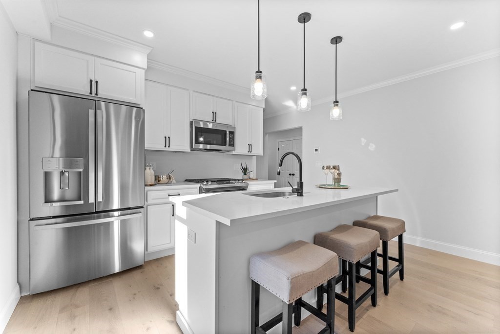 a kitchen with kitchen island a sink appliances and cabinets