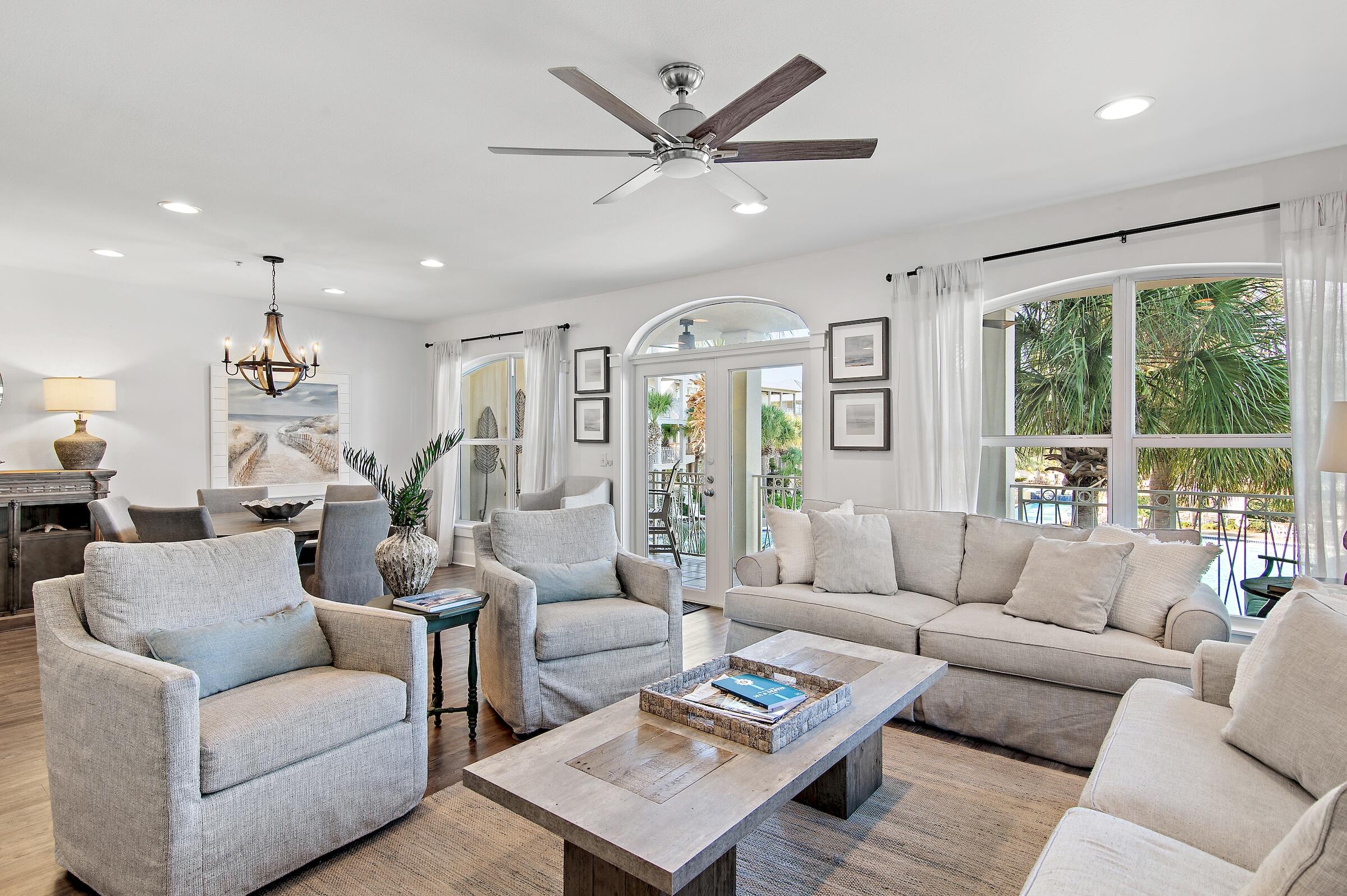 a living room with furniture ceiling fan and a large window