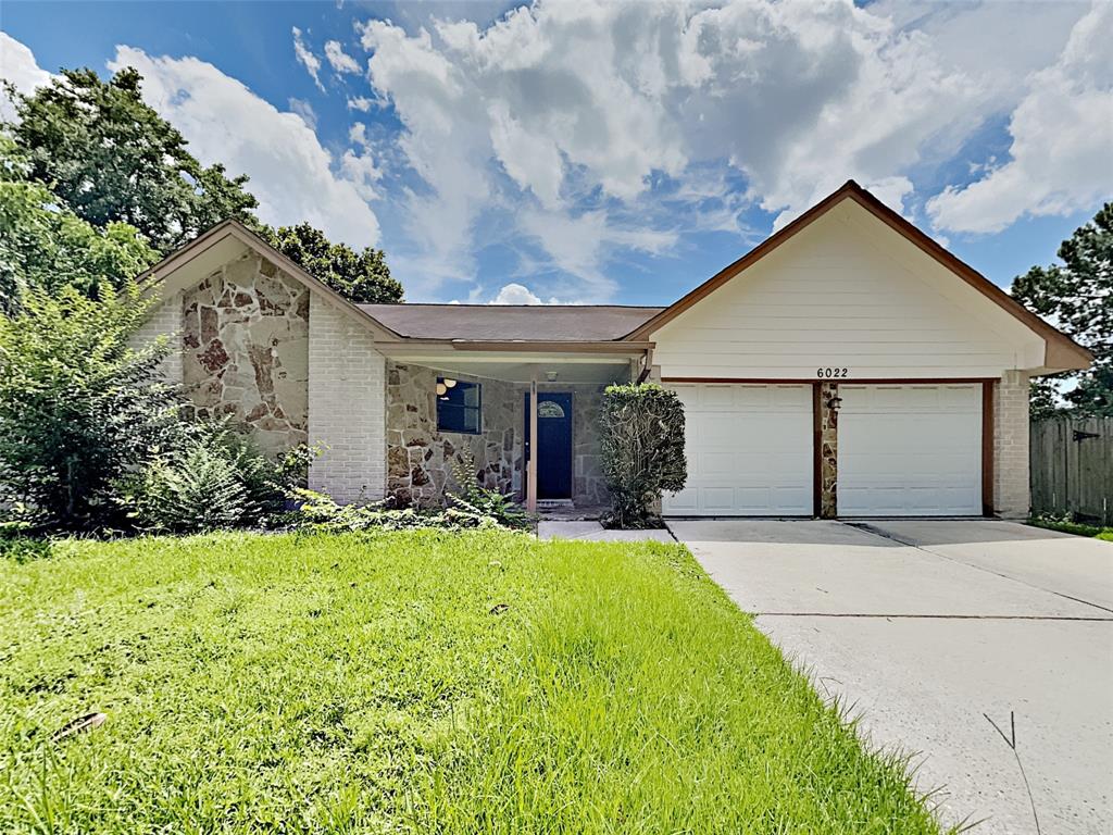 a front view of house with yard and garage