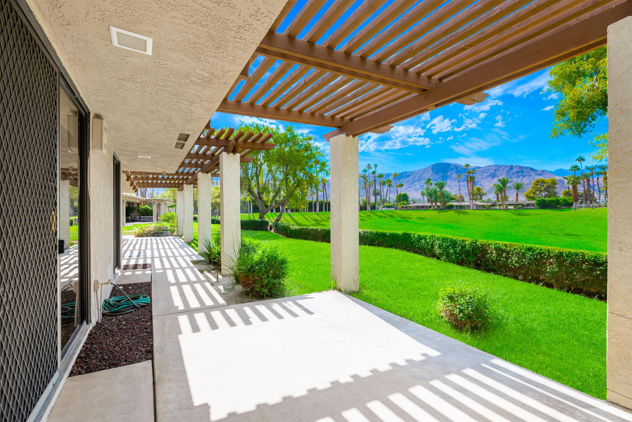 a view of a patio with a table chairs and a yard