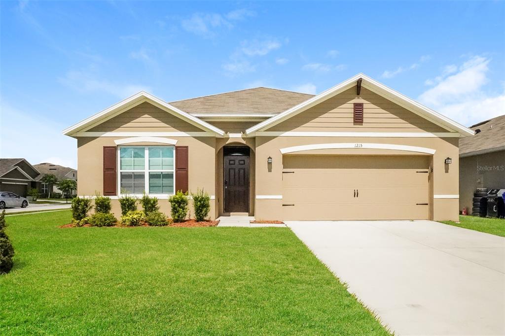 a front view of a house with a yard and garage